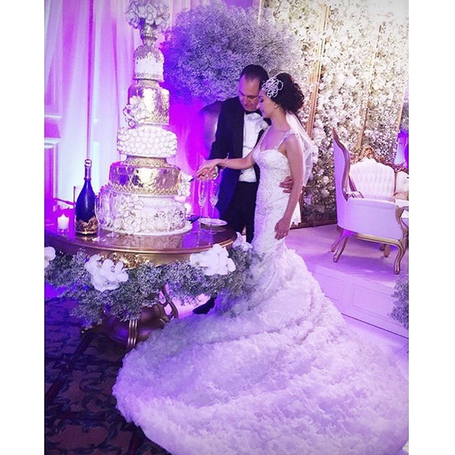 bride in Winnie Couture wedding dress slicing cake 